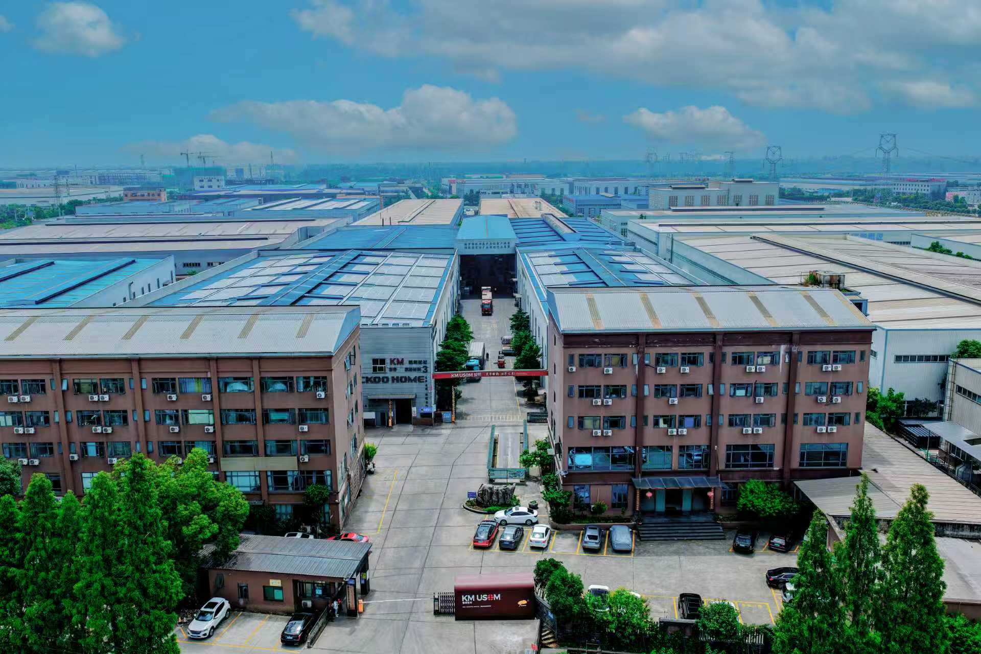 锟明板材厂区航拍,两栋厂房夹着厂区通道,门前为停车场与货运出入口